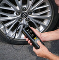 A man inflating a car tire with a Cordless Hand-Held Tire Inflator