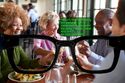 A pair of captioning glasses showing the conversation of a group of people at a table.