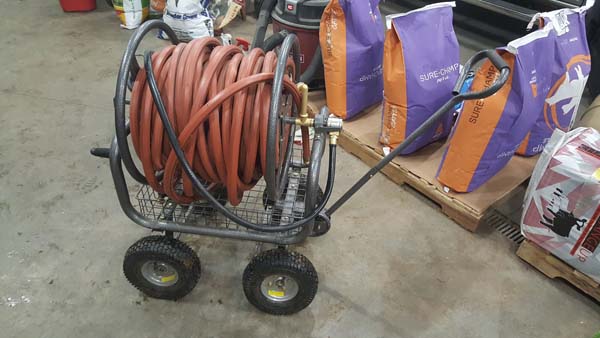 Pictured is a four-wheeled, pull-handled hose-reel cart that’s accommodating a substantial length of hose.