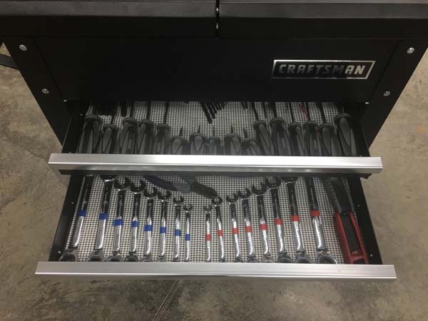 Pictured is an open drawer revealing blue tape on each of seven SAE wrenches and red tape on each of eight metric wrenches, all neatly aligned.