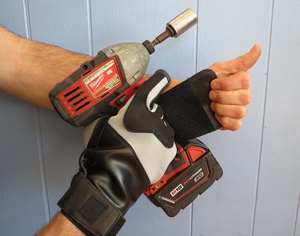 Pictured are two adult male hands holding a cordless impact drill—one hand clad with a full-fingers Velcro glove, the other with a palms-only Velco glove.